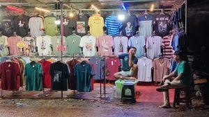 Lagi Duduk Santai, Pedagang Baju di Pasar Malam Kolong Duta Kranji, Keluhkan Sepi Pembeli.