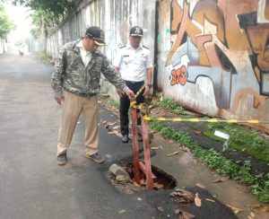 Lurah saat melihat jalan diatas saluran air yang berlubang.