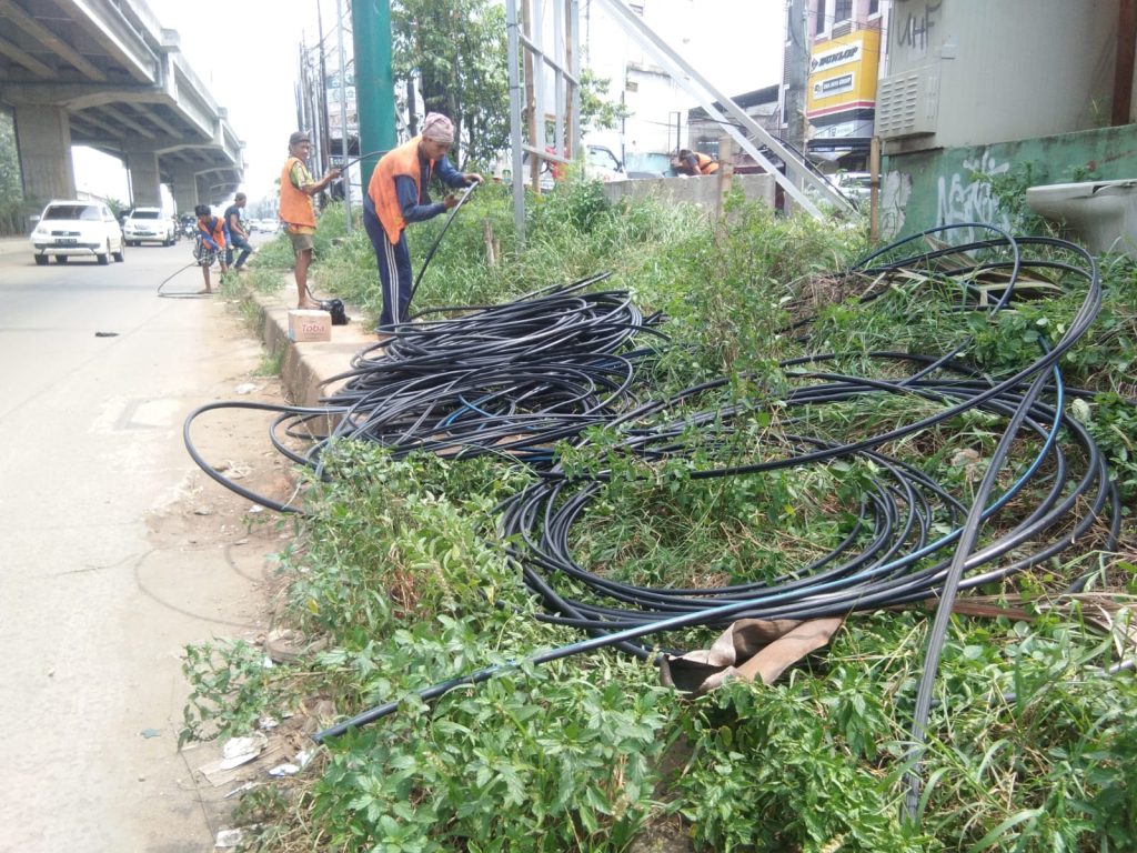 Petugas saat melakukan pembersihan kabel.