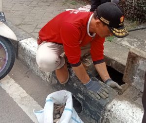 Petugas saat membersihkan saluran drainase di Jl. Ahmad Yani, Kota Bekasi. (Red)